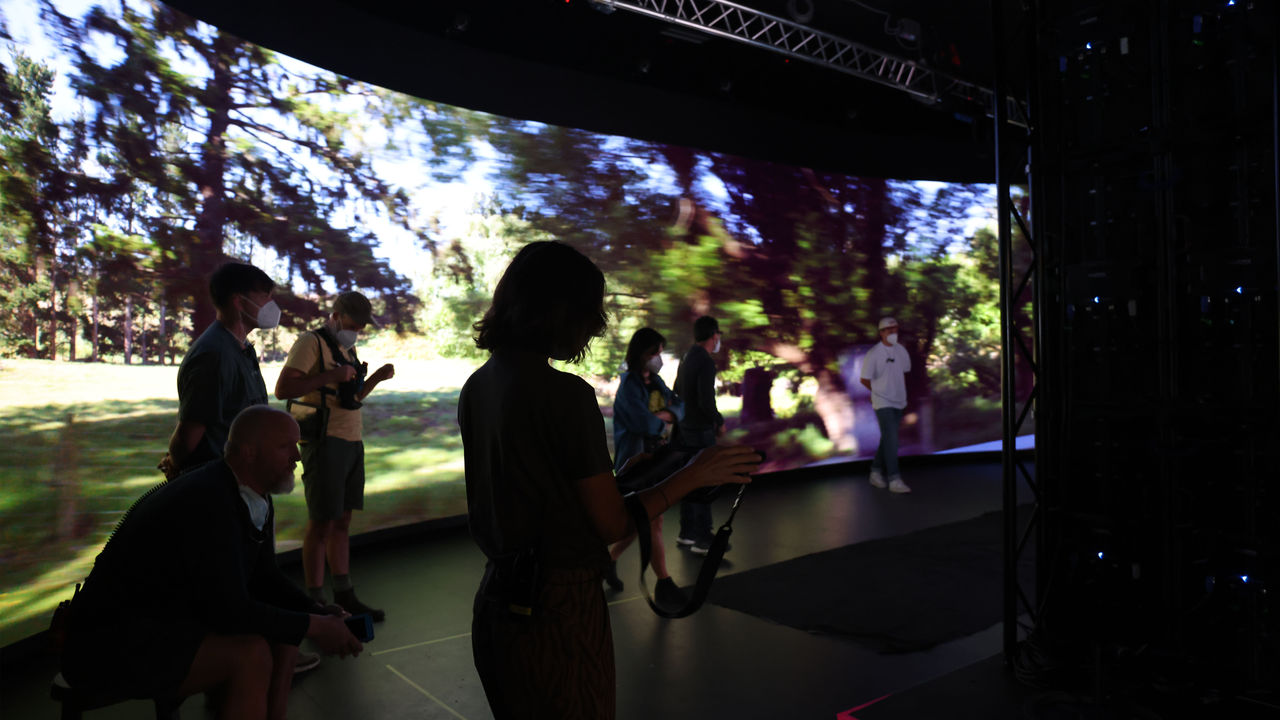 A group of people in front of the virtual production screen while filming