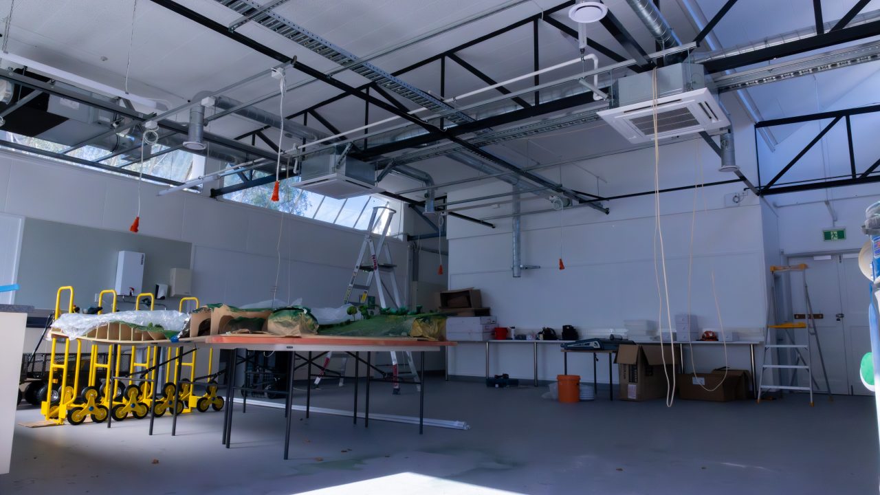 An outside in shot of the Mill workshop space, filled with tables, chairs, and other workstation equipment